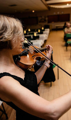 Mira focused on playing violin in a long hall
